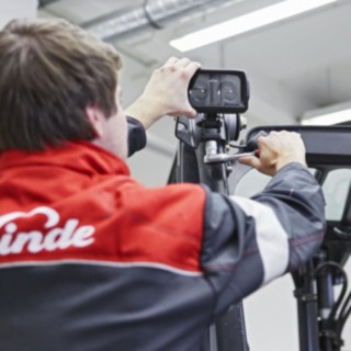 Ein Mechaniker von Linde Material Handling bringt einen Linde BlueSpot am Dach eines Fahrzeugs an.
