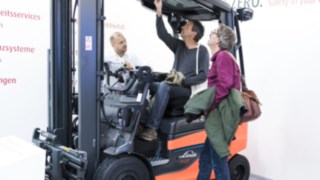 Linde Mitarbeiter zeigt Kunden Sicherheitsfeatures auf der A+A Messe Messestand der Linde Material auf der A+A Sicherheitsmesse