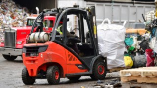Linde V-Stapler transportiert rieseige Müllsäcke