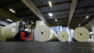 Die Kartonage-Hülse der Papierrolle kommt auf einem 3,10 Meter langen und 23 Zentimeter starken Dorn zu liegen, der ein bisschen wie Pinocchios lange Nase aussieht. Die Kartonage-Hülse der Papierrolle kommt auf einem 3,10 Meter langen und 23 Zentimeter starken Dorn zu liegen, der ein bisschen wie Pinocchios lange Nase aussieht.